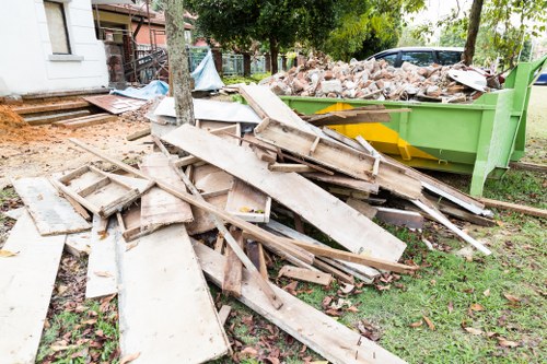 Workers loading a skip safely with PPE